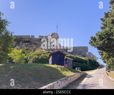 Spalato, Croazia - 1° luglio 2024: Fortezza di Klis, bastioni del punto occidentale e torre di avvistamento Oprah sul passaggio pedonale che conduce all'ingresso sotto il cielo blu. verde tre Foto Stock