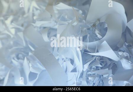 Sfondo a grana di carta sminuzzata, vista dall'alto di molte strisce di carta bianca. Pile di carta tagliata come coriandoli per feste o riempitivi per scatole per spedizioni fragili Foto Stock