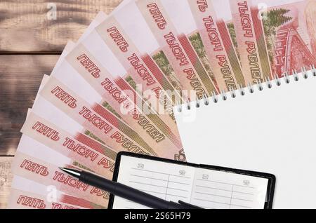 5000 rubli russi banconote ventilatore e blocco note con rubrica e penna nera. Concetto di pianificazione finanziaria e strategia aziendale. Contabilità e. Foto Stock