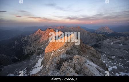 Impressionante paesaggio roccioso di montagna, ripida cresta di montagna, Jubilaeumsgrat con Alpspitze, panorama montano dalla cima dello Zugspitze, alpenglo Foto Stock
