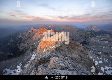 Impressionante paesaggio roccioso di montagna, ripida cresta di montagna, Jubilaeumsgrat con Alpspitze, panorama montano dalla cima dello Zugspitze, alpenglo Foto Stock