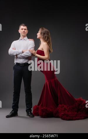 La bella coppia celebra la gravidanza in un abbigliamento elegante durante una sessione in studio Foto Stock