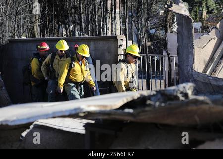 (250116) -- LOS ANGELES, 16 gennaio 2025 (Xinhua) -- i vigili del fuoco controllano le strutture danneggiate da incendi ad Altadena, California, Stati Uniti, 15 gennaio 2025. Mercoledì, nella California meridionale, i vigili del fuoco continuano a combattere numerosi grandi incendi, mentre alcune zone della regione sono attrezzate per affrontare condizioni di fuoco estremamente critiche causate da una nuova ondata di pericolosi venti di Santa Ana. Feroci incendi in tutta l'area di Los Angeles hanno ucciso almeno 25 persone e distrutto più di 12.300 strutture. Le autorità locali hanno confermato che almeno 26 persone erano ancora scomparse in relazione agli incendi in corso. (P Foto Stock