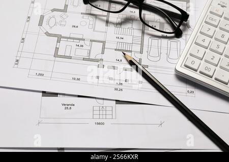 Disegni architettonici diversi, calcolatrice, occhiali e matita, primo piano Foto Stock