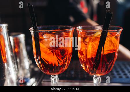 Barman che lavora, bella fila di cocktail alcolici di diversi colori durante una festa all'aperto in un bar, e altri durante il catering banchetto su e. Foto Stock