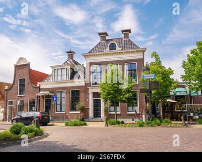 Scena di strada con case storiche su Kerkstraat nella città vecchia di Makkum, Frisia, Paesi Bassi Foto Stock