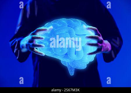 Mani che tengono in mano un ologramma digitale brillante del cervello, che rappresenta la ricerca neuroscientifica e l'innovazione medica. Foto Stock