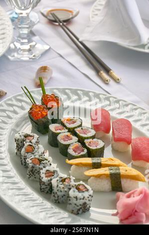Piatto di sushi assortito con Nigiri, Rolls e Garnishes su un piatto bianco Foto Stock