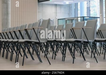 Frammento di una sala conferenze vuota con file di sedie grigie. Foto Stock