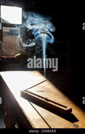 Interessanti schemi di fumo da un bastoncino di incenso acceso sul tavolo della sala da pranzo. REGNO UNITO 2025. Foto Stock