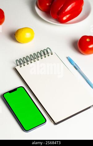 Pianificazione di un menu sano. Smartphone con schermo verde in mano. Calcolo delle calorie. Conteggio dei nutrienti. Mock-up dell'app per il monitoraggio delle calorie. Foto Stock