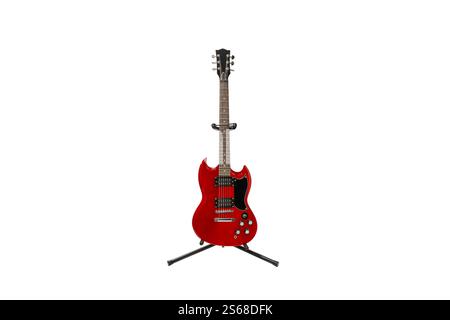 Una chitarra rossa sta su un supporto. Chitarra su sfondo bianco. La chitarra non viene usata. Foto Stock