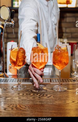 Rinfrescanti cocktail Aperol spritz serviti in un bar, perfetto per celebrazioni e incontri sociali Foto Stock