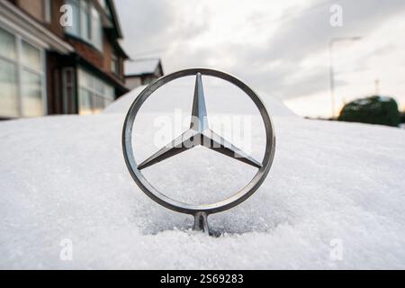 Un simbolo a stella del cofano / stella del cofano a tre punte Mercedes Benz è raffigurato sul cofano / cofano innevato di un'auto / automobile Mercedes Benz Foto Stock