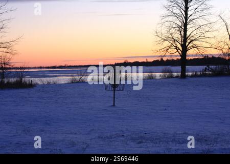 Cestino da golf Metal Disc con sfondo al tramonto sul lago Michigan Foto Stock