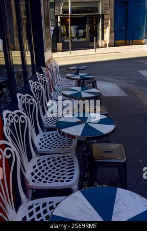 Parigi, Francia, 01.13.2025. Un patio esterno di un ristorante con tradizionali sedie francesi in metallo Foto Stock