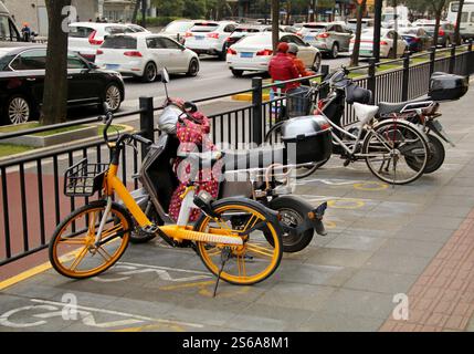 Parcheggio di scooter sulla strada di una città cinese. Foto Stock