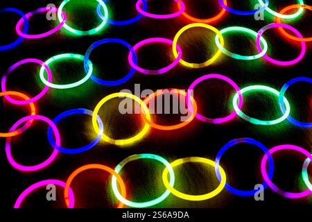 Anelli luminosi disposti in catena su sfondo nero Foto Stock