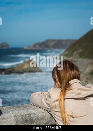 La vista panoramica sulla costa, con scogliere e onde che si infrangono contro le rocce, evoca un senso di pace, riflessione e voglia di vagabondare. Foto Stock