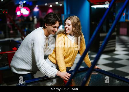 Le coppie amano giocare a hockey da tavolo in un centro ricreativo durante la serata Foto Stock