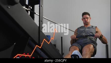 Immagine dell'elaborazione dei dati e dei diagrammi sull'uomo caucasico che usa la macchina per remi in palestra Foto Stock
