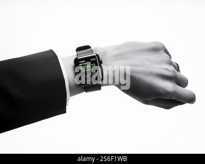 Donna che indossa Apple guardare la serie 2 smartwatch sul suo polso visualizzazione stock market app, primo piano del lato isolato su sfondo bianco in nero e di Pentecoste Foto Stock