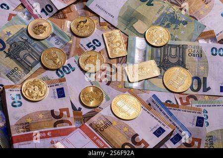 Oro e banconote, barre e monete da oncia, varie banconote in euro in pile e fasci Foto Stock