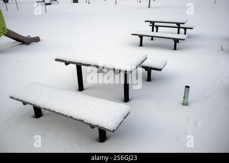 Panche e tavoli coperti di neve nel parco Foto Stock