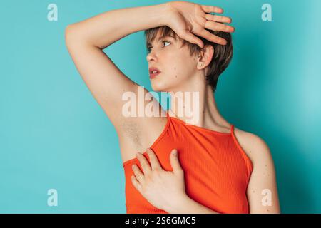 Una giovane donna non rasata che sfoggia le sue ascelle non rasate. Giovane donna positiva al corpo che ha deciso di non radersi. Foto Stock