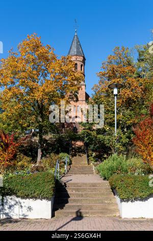Chiesa protestante a Lorsch sulla Bergstrasse circondata da splendidi alberi autunnali colorati, in Germania Foto Stock
