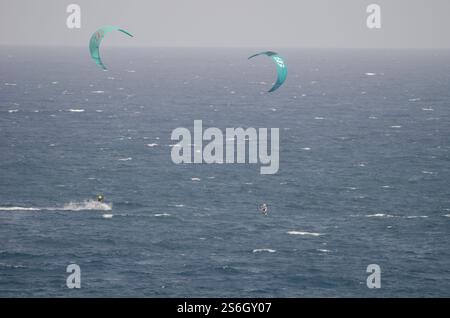 I kiteboarder vengono tirati sull'acqua da un aquilone. Los Cristianos. Tenerife. Isole Canarie. Spagna. Foto Stock