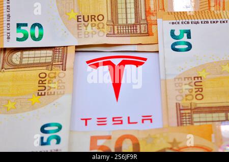 17 gennaio 2025, Firenze Italia, in questa foto illustrazione, logo Tesla con banconote in euro. Foto Stock