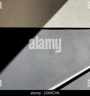 Design geometrico minimalista con ombre e linee diagonali sulle superfici testurizzate, che evocano equilibrio e semplicità. Foto Stock