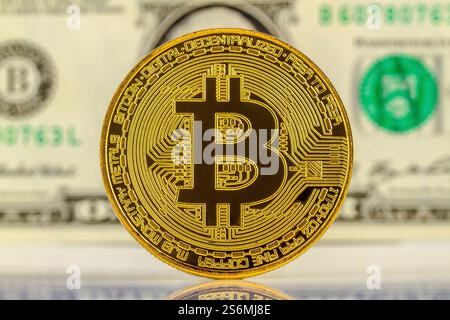 Bitcoin con banconote in dollari sullo sfondo Foto Stock