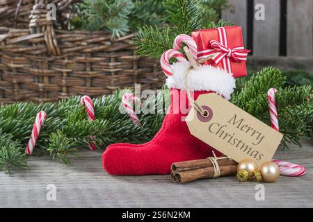 Cartolina di Natale inglese con calzino natalizio rosso con regali e canne di caramelle Foto Stock