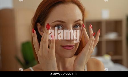 Attraente donna rossa con una bella pelle che gode di un trattamento spa all'interno di un centro benessere. Foto Stock