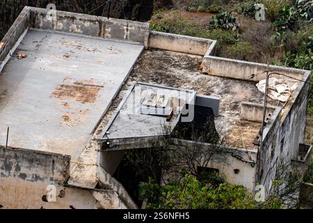 Una casa con un tetto coperto di sporcizia e detriti. Anche il tetto è coperto di muschio Foto Stock