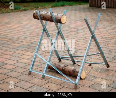 Dettagli di un seghetto con tronco e sega durante un matrimonio Foto Stock