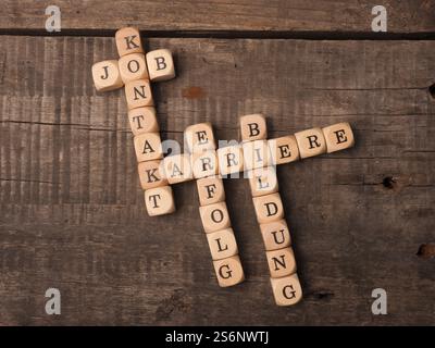 In tedesco il concetto di carriera con il cruciverba carriera, istruzione, lavoro, il successo e il contatto su una tavola in legno rustico Foto Stock