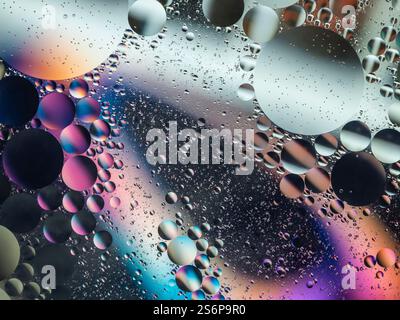 Immagine astratta vibrante con bolle d'acqua e olio colorate che creano un motivo testurizzato. Perfetto per ambienti artistici, scientifici o creativi. Foto Stock