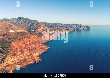 Costa rocciosa con cielo azzurro. Vista sul mare la sera. Vista aerea dalla spiaggia di Maro alla Grotta dei piccioni e al punto panoramico di Cerro Gordo. Viadotto la Miel Foto Stock