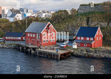 Naviga lungo la costa della Norvegia, contrasti nella città di Bodo, tradizionali case di legno rosse sull'isola di Nyholmen Skandse con un'antica fortezza di fronte a un quartiere moderno Foto Stock