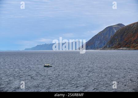 Naviga lungo la costa della Norvegia, pesca d'altura su un piccolo motoscafo, calmo mare norvegese al largo dell'isola di Soroya Foto Stock