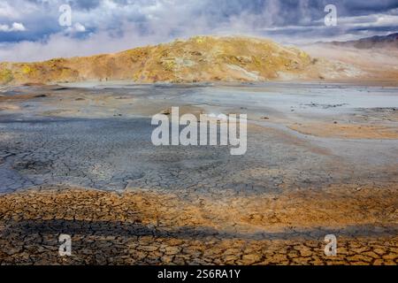 Paesaggio vulcanico di Hverir, area geotermica di Myvatn in Islanda, con terreno cranizzato arancione e piscine termali e ruscelli. Foto Stock