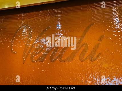 01 17 2025 - Firenze, Italia. Logo Venchi su una parete con cioccolato che scorre. Cioccolateria Venchi e gelateria. In tutto il mondo conoscono la gelateria Foto Stock
