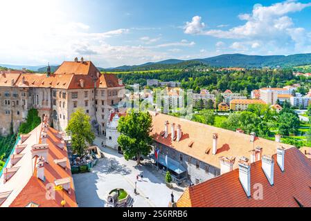 Il cortile del Castello di Cesky Krumlov mette in mostra la sua architettura storica, circondata da vegetazione lussureggiante e montagne, che riflettono il fascino del paesaggio cecoslovacco. Foto Stock