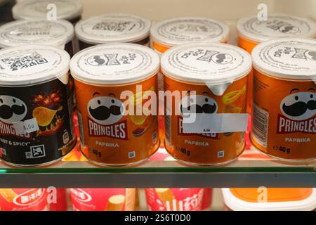 Minsk, Bielorussia - 16 agosto 2024: Lattine colorate di Pringle in vari gusti sono disposte su uno scaffale del negozio. La confezione luminosa aggiunge energia vivace al negozio Foto Stock