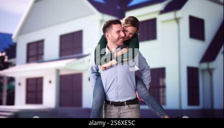 Ritratto di una famiglia felice in piedi al di fuori della loro casa con pannelli solari sul tetto Foto Stock