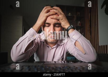 Uomo d'affari ufficio che lavora tenendo mal di testa dolore dalla scrivania di lavoro e di seduta tutto il giorno utilizzando computer portatile che soffrono mal di testa lavoratore malato overworki Foto Stock