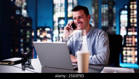Uomo d'affari che parla con il cliente al telefono. Uomo che usa computer e smartphone Foto Stock